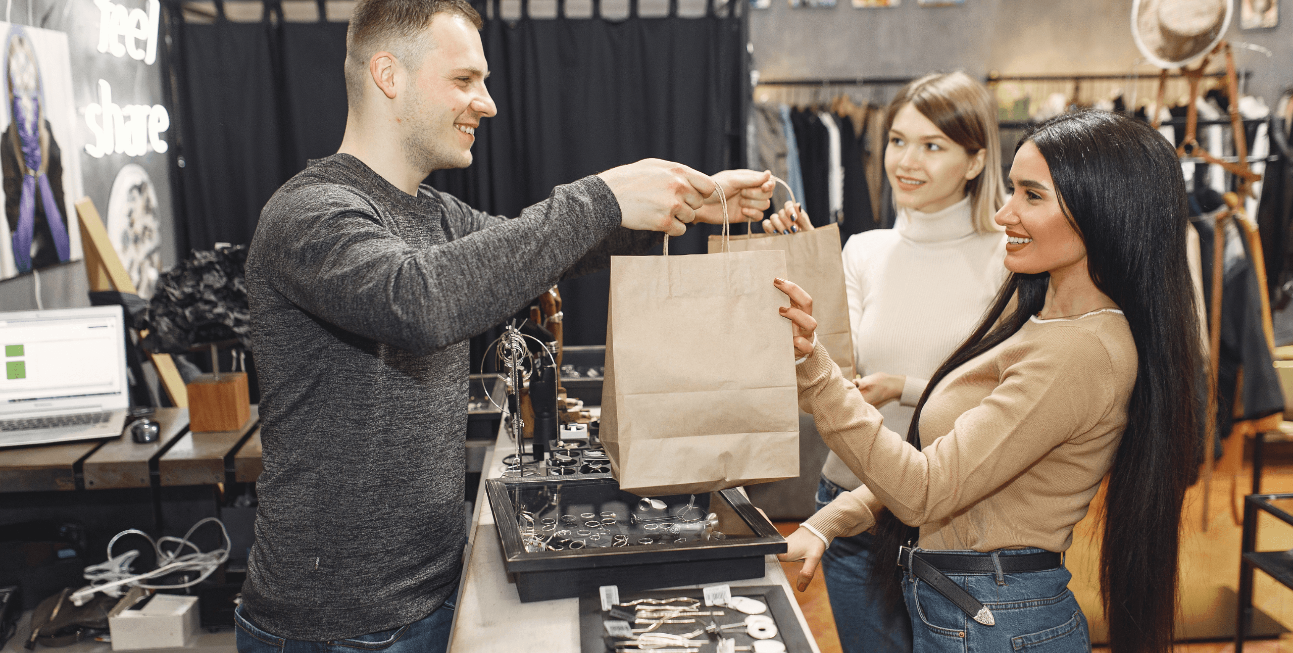 Retail Store man handing over paper bags to customers