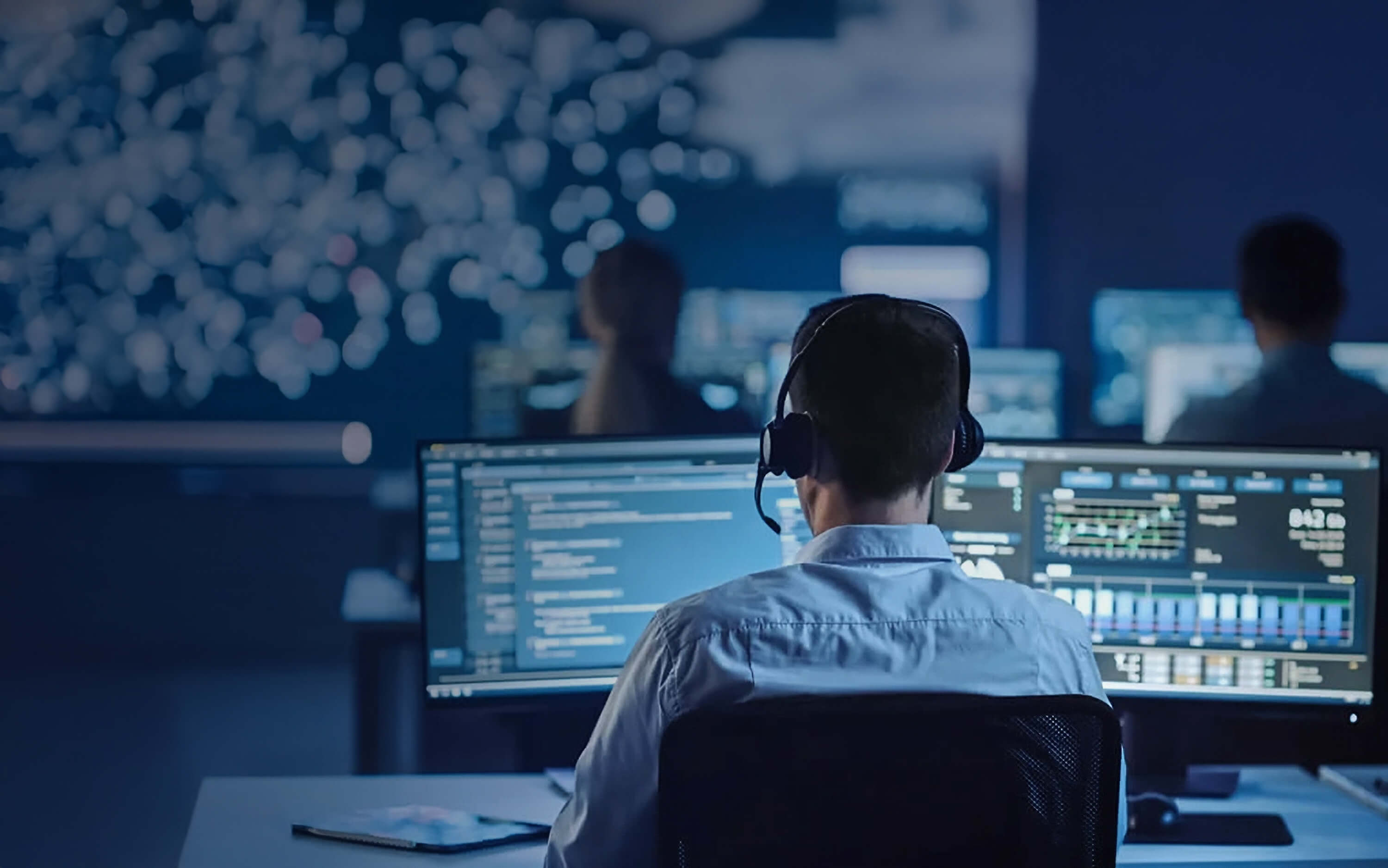 Man Working with Headset in Front of a computer