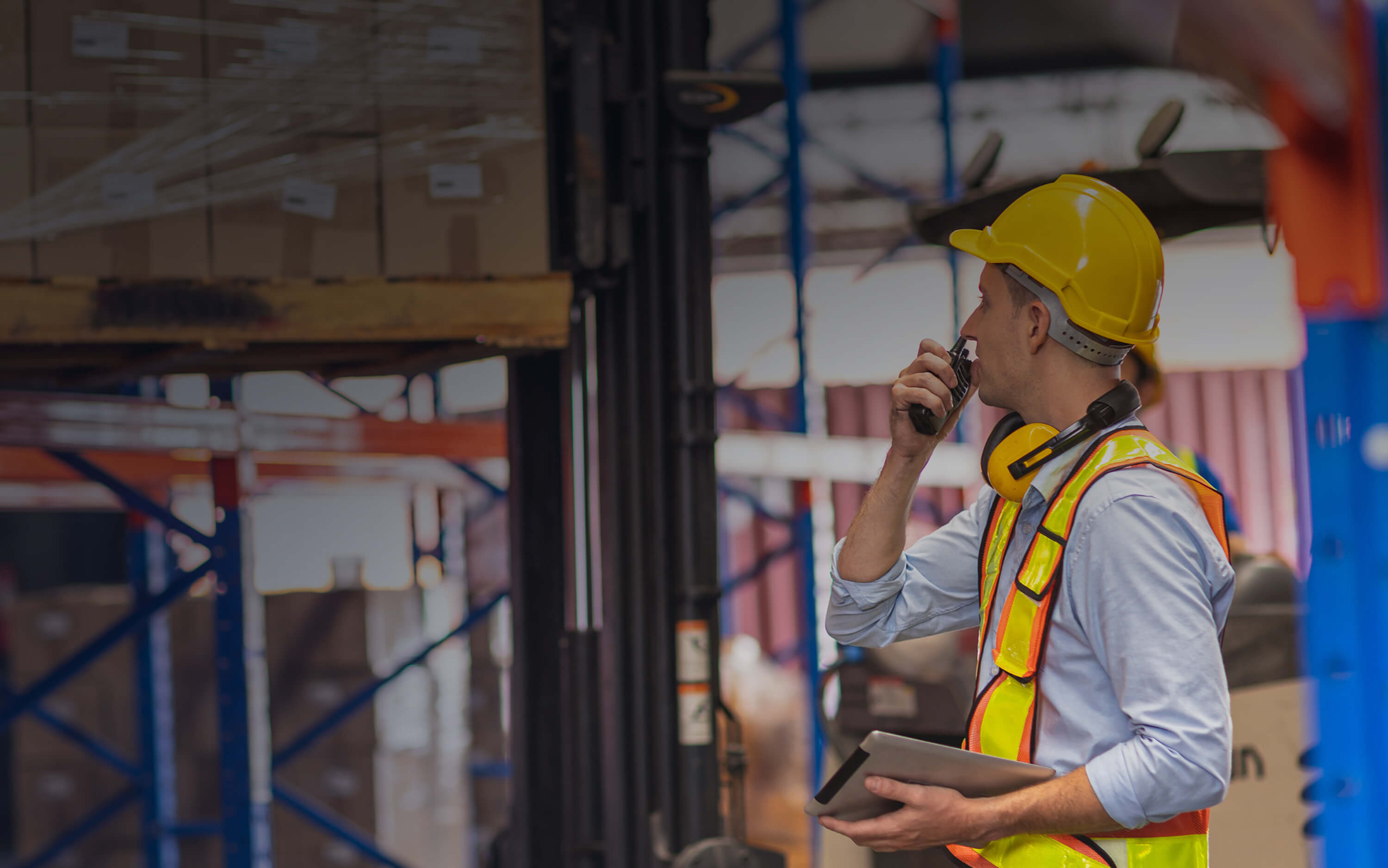 Talking on a walkie talkie in a warehouse