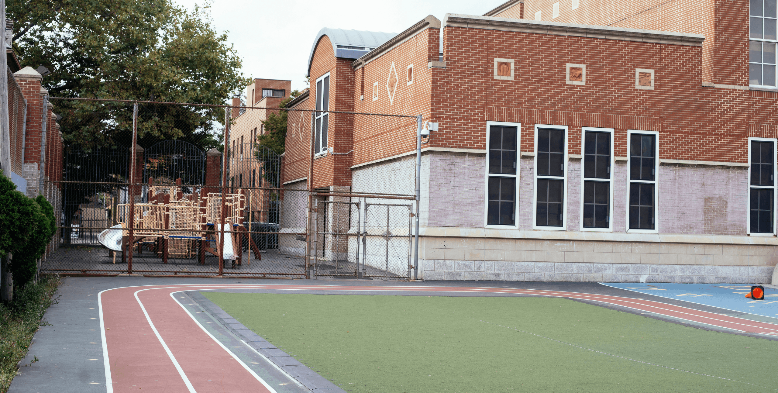 School building with a playground and sports field
