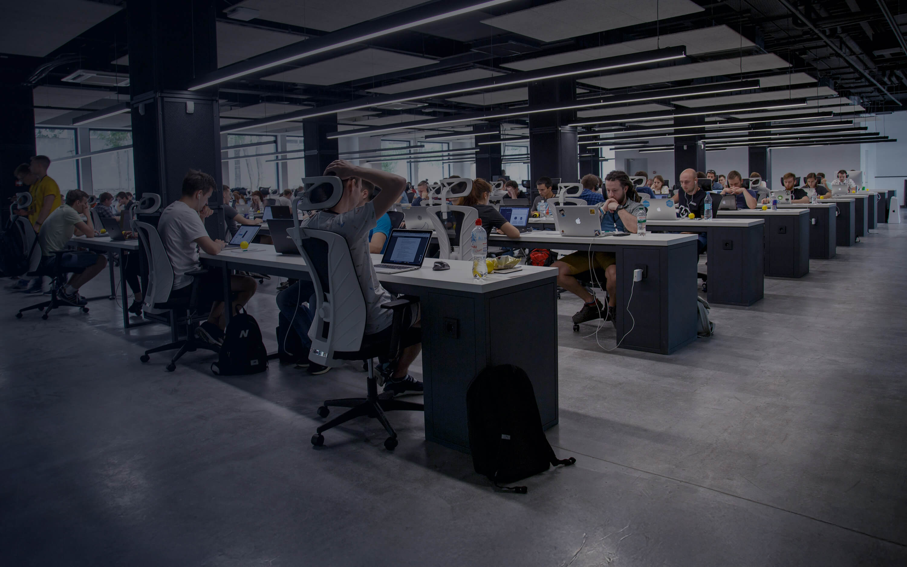 Rows of desks with people working on computers